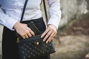 woman taking gun out of her purse