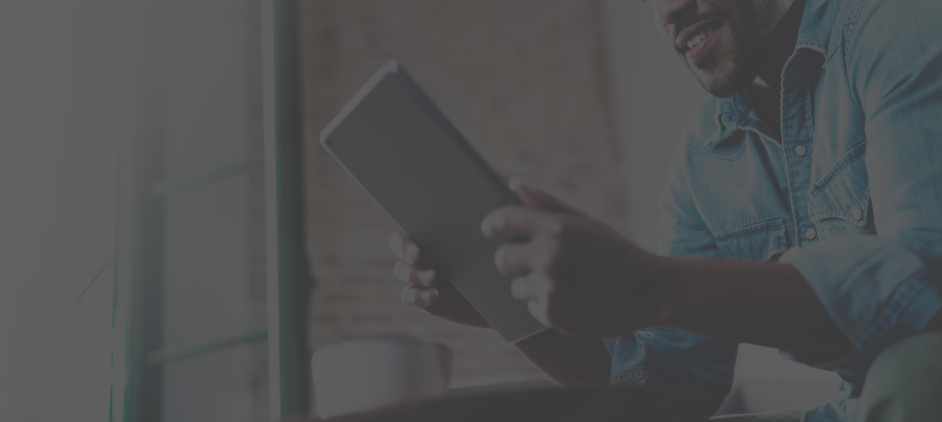 Bearded smiling African man using tablet for video conversation