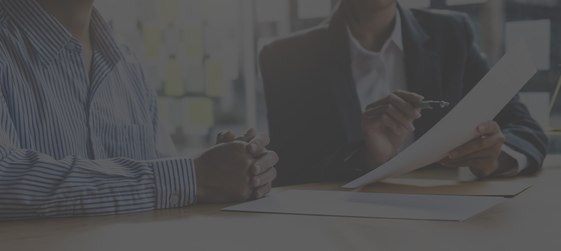 Female lawyer is explaining the terms of the legal contract document and asking the client to sign it properly