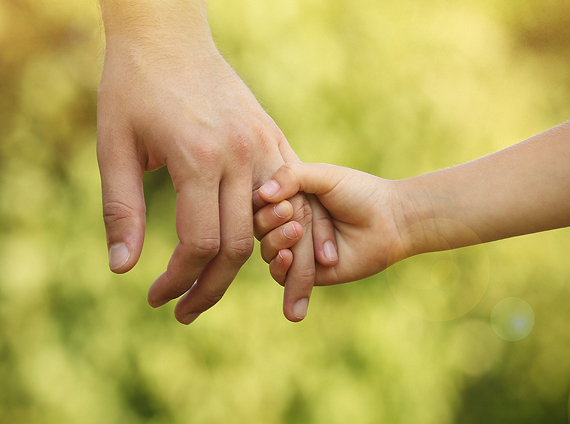 adult hand holding a child's hand