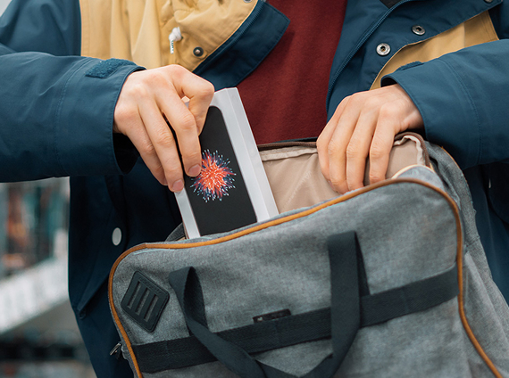 person placing a stolen iphone into a bag